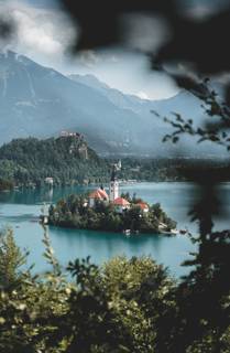 Bleder See (Bled Jezero) - Ein malerischer Blick auf den glitzernden Bleder See mit der Insel und der charmanten Kirche im Hintergrund.