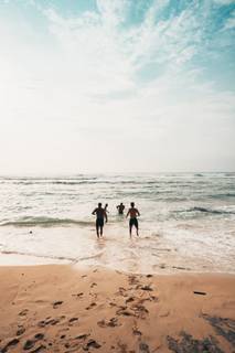 Menschen genießen den Strand, Baden und Schwimmen im Meer.