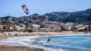 Ein Surfer genießt die Wellen an einem sonnigen Strand in Marseille, Frankreich.